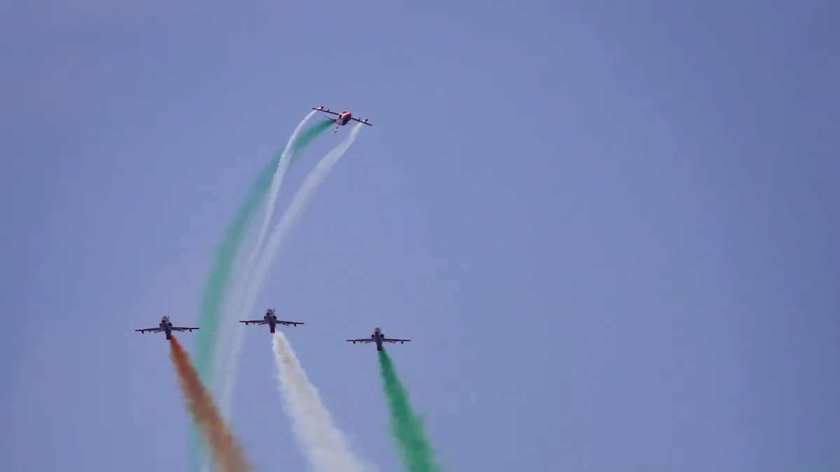 Namo Ghat air show: Suryakiran Hawk jets trailing saffron, white and green smoke during an aerobatic display